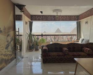a living room with a couch and a view of the pyramids at Giza Pyramids View Guest House in Cairo