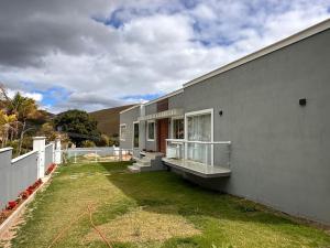 a house with a yard next to a building at Sereno Paty Retreat - near Paty Agro Show in Paty do Alferes