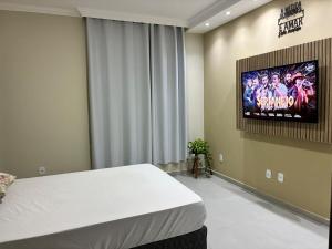 a room with a bed and a tv on the wall at Sereno Paty Retreat - near Paty Agro Show in Paty do Alferes