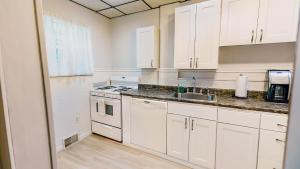 a kitchen with white cabinets and a sink at Massive 4 Bed House-Short Walk to Amazing View in Pittsburgh