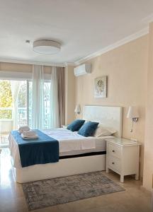 a bedroom with a large bed with blue pillows at Playa Albir Apartments in Albir