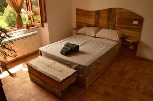 - une chambre avec un grand lit et une tête de lit en bois dans l'établissement Agriturismo Riparossa, à Allerona