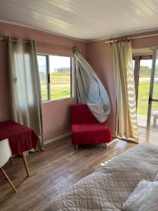 ein Schlafzimmer mit einem Bett und einem Stuhl und einem Fenster in der Unterkunft Da Fortune 4 in Barra de Portezuelo + 21 Fotos