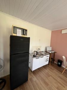 eine Küche mit einem schwarzen Kühlschrank und einem Tisch in der Unterkunft Da Fortune 4 in Barra de Portezuelo