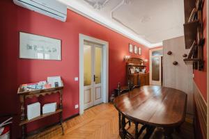 a dining room with red walls and a wooden table at Antico Villino - Elegant Accommodation with Parking in Conegliano