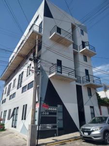 a building with a car parked in front of it at Living Universidad in El Gallinero