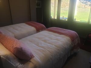 two beds in a room with a window at The Bluffs Villa in Queenstown