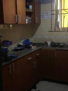 une cuisine avec des armoires en bois et un comptoir dans l'établissement DarcoM, à Ile-Ife