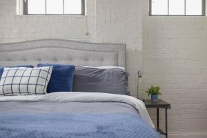 a bedroom with a bed with blue and white pillows at New Downtown JC Loft! in Johnson City