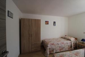 a bedroom with two beds and a wooden cabinet at L'incantevole vista in Colico