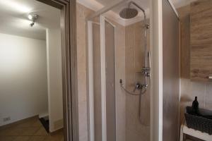 a shower with a glass door in a bathroom at L'incantevole vista in Colico
