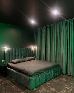 a bed in a room with a green curtain at Suite Emeraude in Saint-Étienne