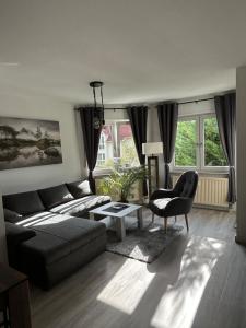 a living room with a couch and a chair at Moderne 75m2 Wohnung mit Balkon und Blick ins Grüne in Magdeburg