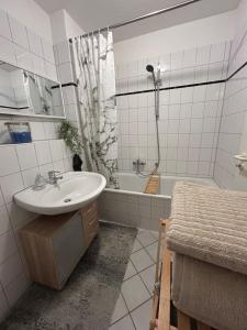 a white bathroom with a sink and a shower at Moderne 75m2 Wohnung mit Balkon und Blick ins Grüne in Magdeburg