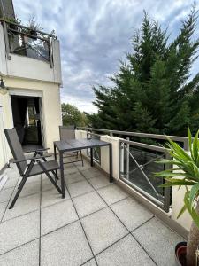 a patio with a table and chairs on a balcony at Moderne 75m2 Wohnung mit Balkon und Blick ins Grüne in Magdeburg +6 photos