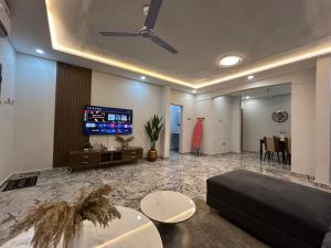 Una sala de estar con un sofá y un televisor de pantalla plana. en OB DELUXE Apartments 1, en Accra