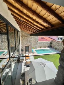 un patio intérieur avec un parasol et une piscine dans l'établissement El Pajar de Rascafría, à Rascafría