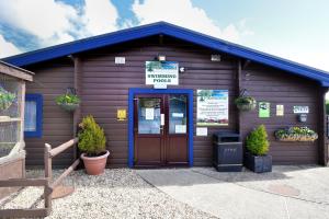 a brown building with a door and a sign on it at 10 Pinewood Retreat in Lyme Regis