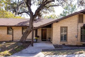 ein Backsteinhaus mit einem Baum davor in der Unterkunft Texas Hill Country Resort in Medina