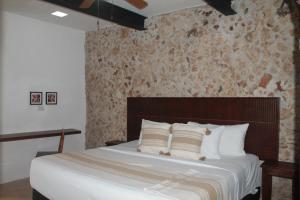 una camera da letto con un letto grande con cuscini bianchi di Casa Esquina Suite 1 a Mérida Altre 32 foto