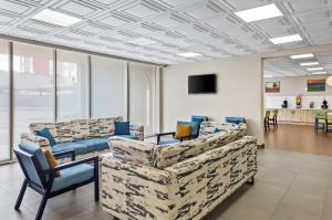 a waiting room with couches and chairs and a tv at Quality Inn & Suites Charleston - Civic Center in Charleston