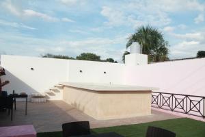 un muro bianco con un tavolo su un patio di Casa Esquina Suite 1 a Mérida