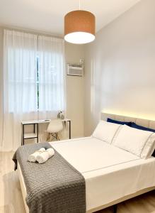 een slaapkamer met een groot wit bed en een tafel bij Apartamento à Beira-Mar na Urca in Rio de Janeiro