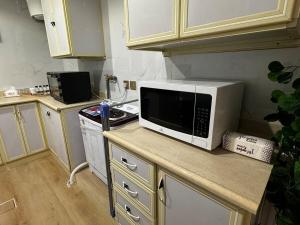 阿可贺巴Comfortable three-bedroom apartment in Olaya的厨房在柜台上配有微波炉 更多14张照片