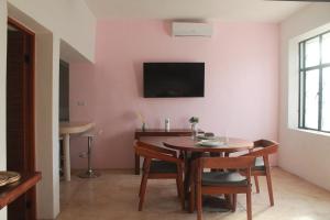 una sala da pranzo con un tavolo e una TV a parete di Casa Esquina Suite 1 a Mérida