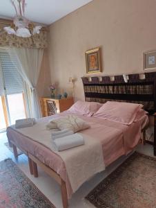 a bedroom with a large bed with pink sheets at MAMY PENTHOUSE in Palermo +32 photos