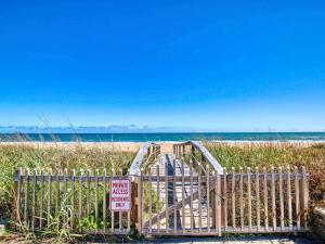 a boardwalk leading to a beach with a no entry sign at Sunrise Cottage by the Sea in Ormond-by-the-Sea