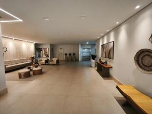 eine Lobby mit einem langen Flur mit Sofas und Tischen in der Unterkunft Alto Padrão, Vista Mar, Varanda Gourmet, Nascente Compartilhar SalvarHigh Standard, Sea View, Gourmet Balcony, East-facing in Guarapari