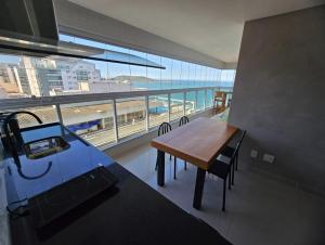 eine Küche mit Tisch und Blick auf das Meer in der Unterkunft Alto Padrão, Vista Mar, Varanda Gourmet, Nascente Compartilhar SalvarHigh Standard, Sea View, Gourmet Balcony, East-facing in Guarapari