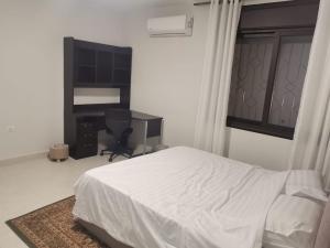 a bedroom with a bed and a desk and a computer at 2 Master Bedroom Deluxe Apartment Queen Alia Airport Families Women ONLY in Amman