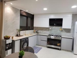 a kitchen with a stove and a dishwasher at 2 Master Bedroom Deluxe Apartment Queen Alia Airport Families Women ONLY in Amman