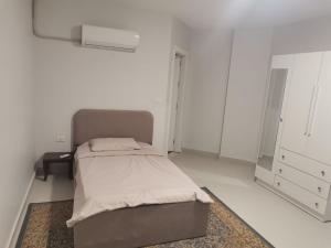 a white room with a bed and a mirror at 2 Master Bedroom Deluxe Apartment Queen Alia Airport Families Women ONLY in Amman +8 photos