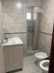 a bathroom with a toilet and a sink and a shower at Casa en La Caleta Normandita in Mar de Cobo +29 photos