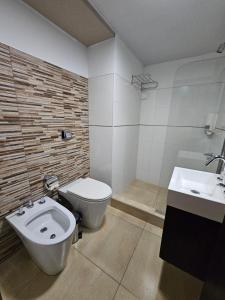 a bathroom with a toilet and a sink at Hotel Grand Lago in Posadas +44 photos