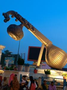 a large golden ladle hanging over a crowd of people at Hotel Ramayanam palace in Ayodhya