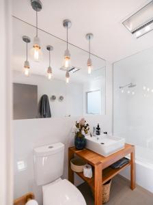a white bathroom with a sink and a toilet at The Barefoot Beach House - Surf Beach in Surf Beach