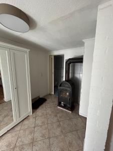 an empty living room with a stove in a room at Idyllic and quiet location in Obersulm