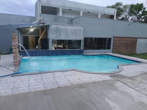 a swimming pool in front of a house at Chácara Fim de Tarde in Barra do Garças