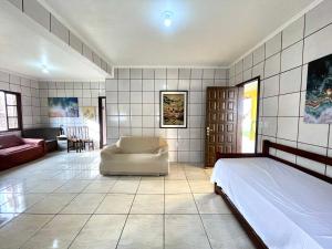 a bedroom with a bed and a living room at Nossa pousada in Imbituba