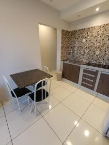 a kitchen with a table and chairs in a room at Apart cómodo y seguro a pasos de todo in Ciudad del Este