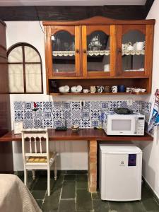 a kitchen with a counter top with a microwave at Recanto das Águas Claras in São José do Rio Prêto +21 photos