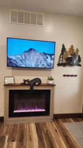 a living room with a fireplace and a flat screen tv at Parkside Cabins in West Yellowstone