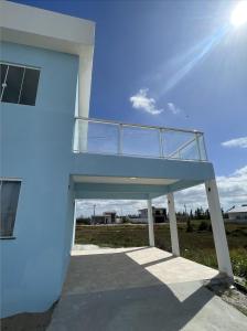 a blue building with a balcony on top of it at Ventos de Arubinha in Arraial do Cabo
