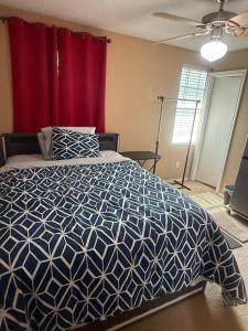 a bedroom with a blue and white bed with a red curtain at Elegant Texas Home, Minutes from DFW Adventures in Justin