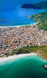 an aerial view of a beach and the ocean at Passeios pelas praias mais cristalinas de Caribe brasileiro in Arraial do Cabo