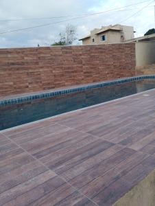 a brick retaining wall with a wooden deck at Excelente casa in Búzios